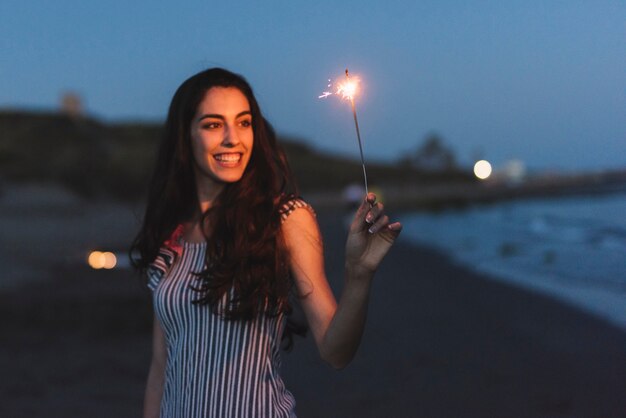 Ragazza con sparkler in spiaggia