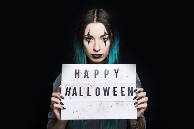 Ragazza con trucco e insegna di Halloween