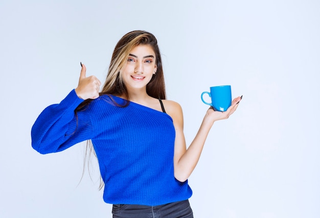 Ragazza con una tazza di caffè e godersi il gusto.