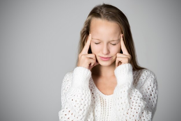 Ragazza concentrata con le dita sulla fronte