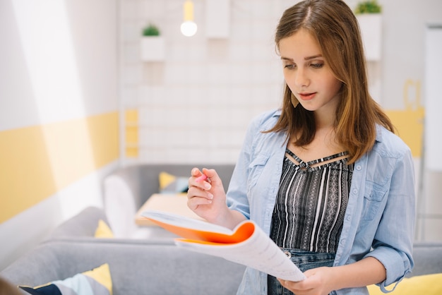 Ragazza concentrata posa con il libro di testo