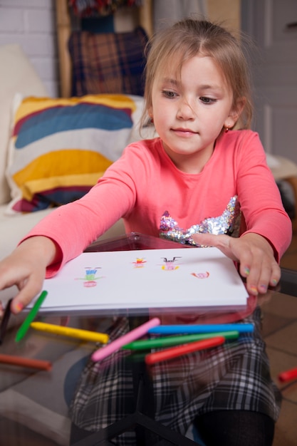 Ragazza concentrata scegliendo un disegna da disegnare