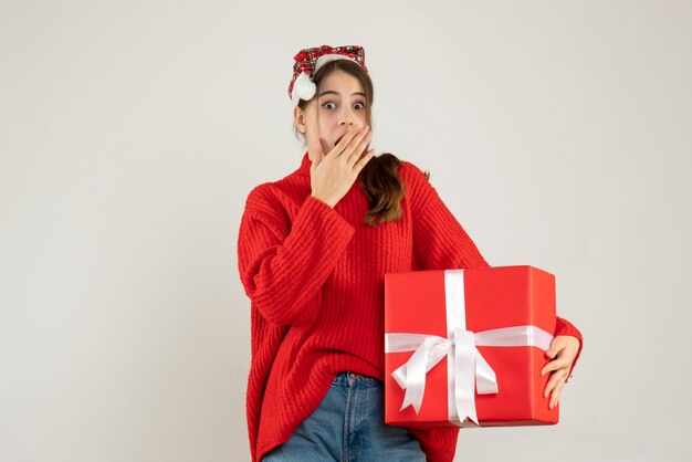 Ragazza confusa di vista frontale con il cappello della Santa che tiene la mano mettendo presente