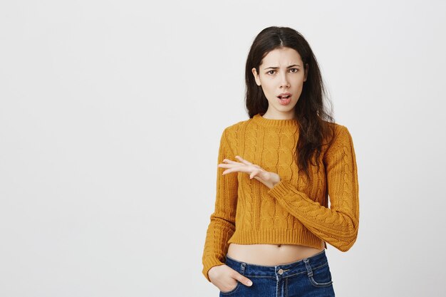 Ragazza confusa e delusa che discute, alzando la mano perplessa, facendo domanda