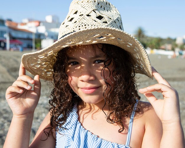 Ragazza da vicino che indossa un cappello sulla spiaggia