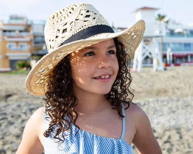 Ragazza da vicino che indossa un cappello sulla spiaggia