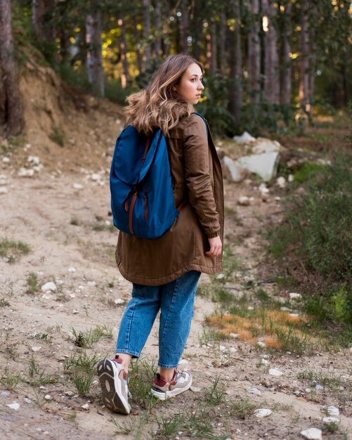 Ragazza dai capelli castani colpo completo nella foresta