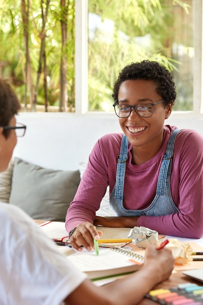 Ragazza dalla pelle scura sorridente soddisfatta con espressione positiva