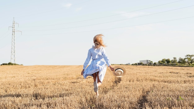 Ragazza del colpo lungo che corre in un campo