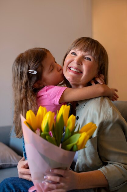 Ragazza del colpo medio che bacia la nonna