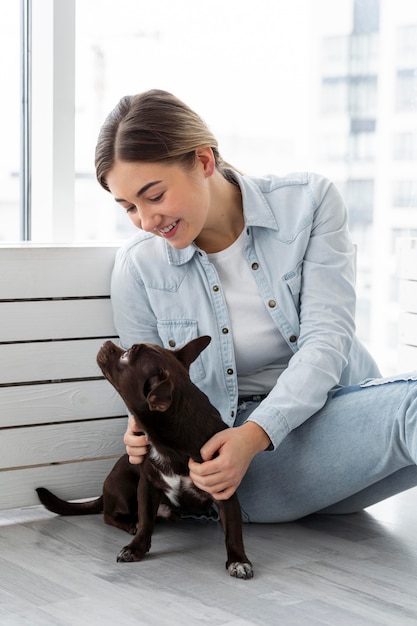 Ragazza del colpo medio che gioca con il cane