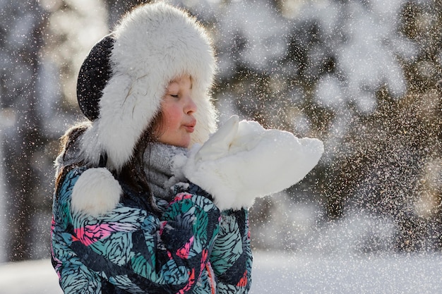 Ragazza del colpo medio che gioca con la neve