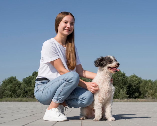 Ragazza del colpo pieno che accarezza il cane sveglio