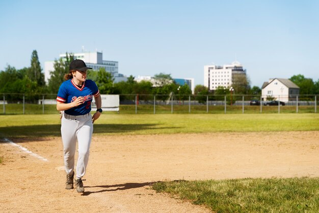 Ragazza del colpo pieno che corre sul campo