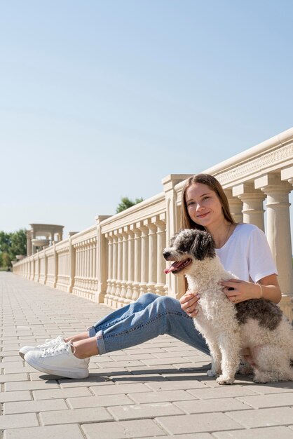 Ragazza del colpo pieno che tiene cane sveglio