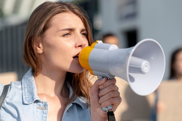 Ragazza del primo piano che protesta con il megafono