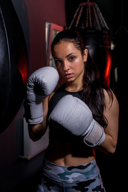 Ragazza del pugile che posa in palestra