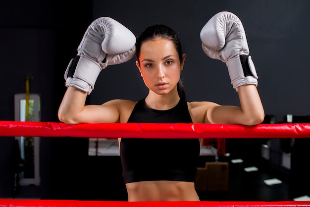 Ragazza del pugile che posa in palestra