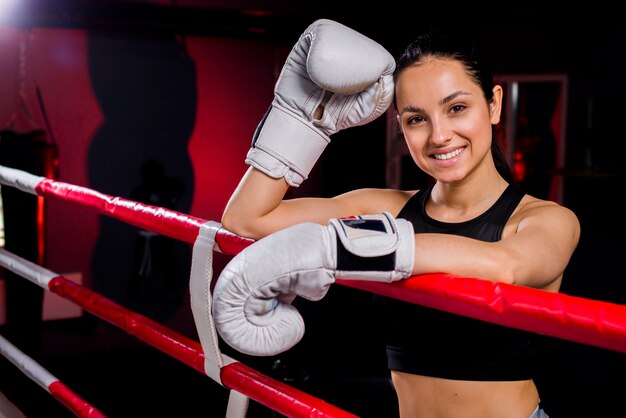 Ragazza del pugile che posa in palestra