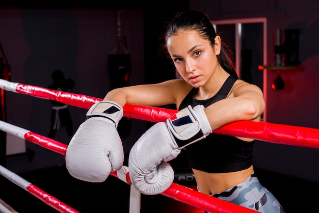 Ragazza del pugile che posa in palestra