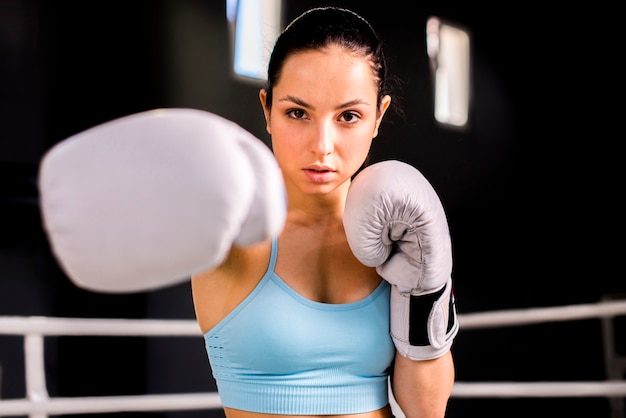 Ragazza del pugile che posa in palestra