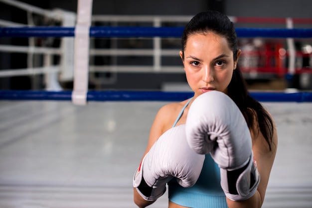 Ragazza del pugile che posa in palestra