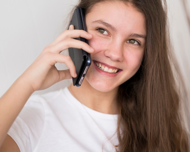 Ragazza del ritratto che parla sopra i telefoni