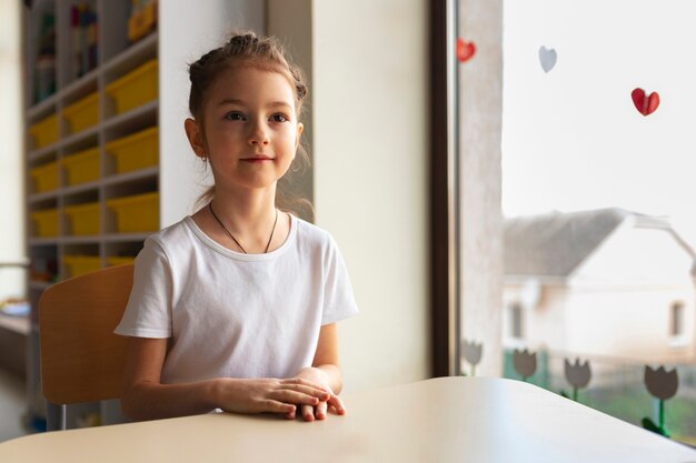 Ragazza del tiro medio che impara a scuola