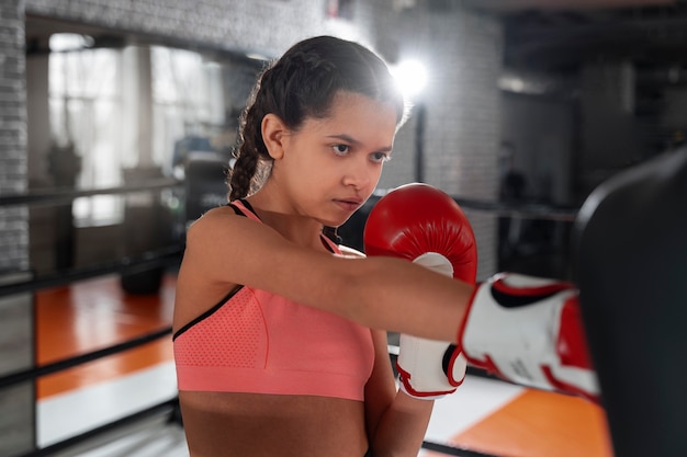 Ragazza del tiro medio che impara la boxe