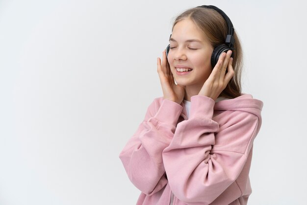 Ragazza del tiro medio che indossa le cuffie