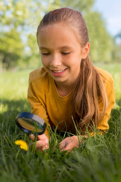 Ragazza del tiro medio che osserva il fiore