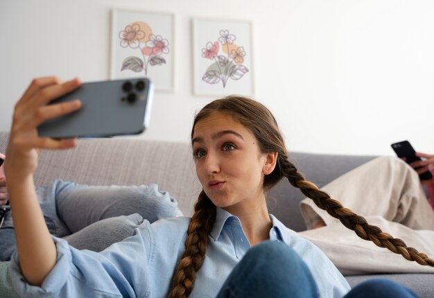 Ragazza del tiro medio che prende selfie