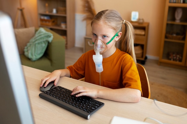 Ragazza del tiro medio che usa il nebulizzatore