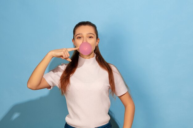 Ragazza dell'adolescente che gonfia bolla di gomma