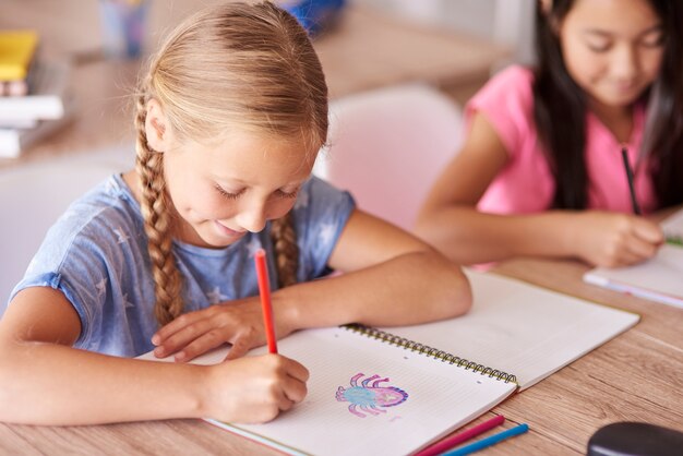 Ragazza dell'allievo che disegna durante la lezione