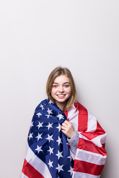 Ragazza dell'allievo che tiene una bandiera americana isolata