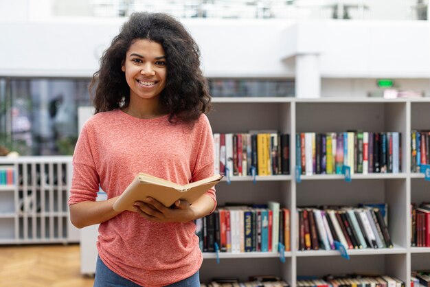 Ragazza dell'angolo alto alla lettura delle biblioteche