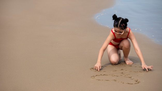 Ragazza dell'angolo alto che gioca sulla sabbia