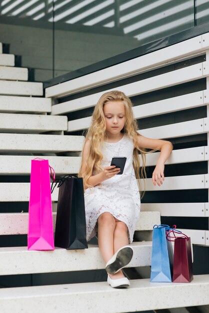 Ragazza della foto a figura intera che osserva sul telefono