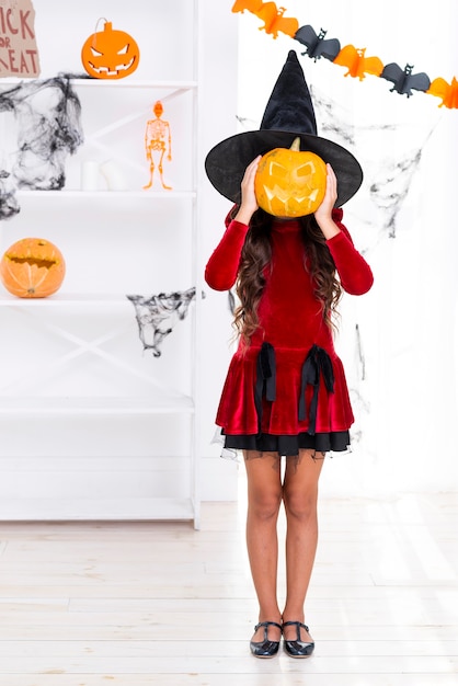 Ragazza della foto a figura intera che tiene la zucca di Halloween