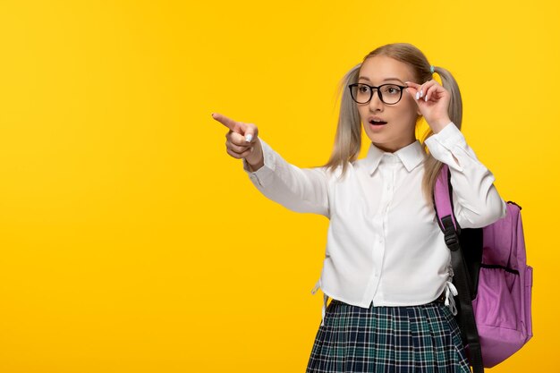 Ragazza della giornata mondiale del libro in uniforme scolastica carina con zaino rosa