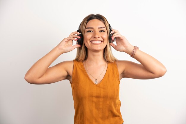 Ragazza della giovane donna in vestiti casuali che posano con le cuffie.