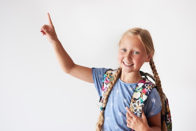 Ragazza della scuola che indica dalla mano destra