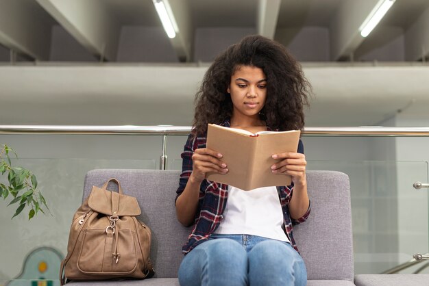 Ragazza di angolo basso sulla lettura dello strato