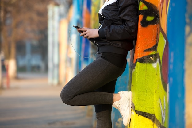 Ragazza di corridore con il telefono mobile, primo piano