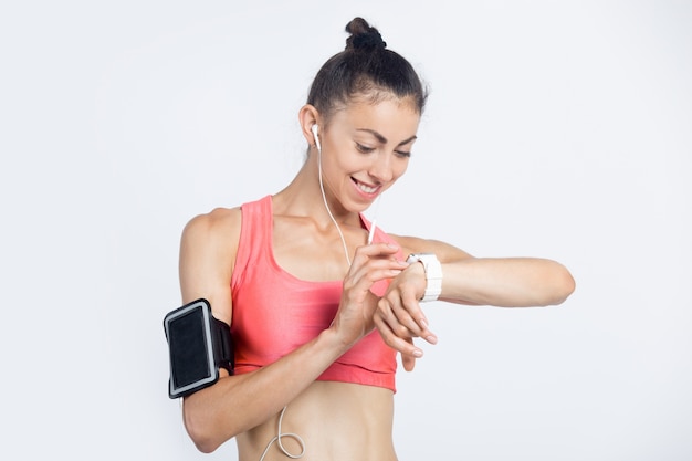 Ragazza di fitness che controlla il progresso dell&#39;allenamento sull&#39;orologio astuto