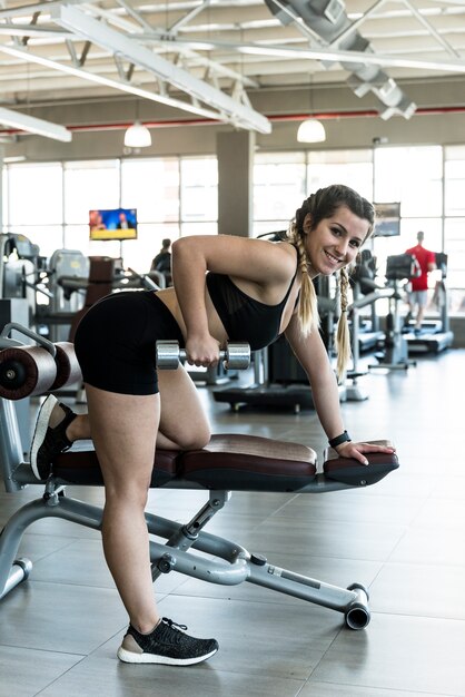 Ragazza di forma fisica che usando dumbball