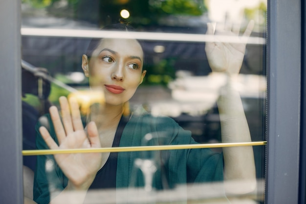 Ragazza di moda in piedi in un caffè estivo