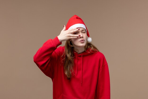 Ragazza di natale di vista frontale che posa sull'emozione marrone di natale di festa del fondo