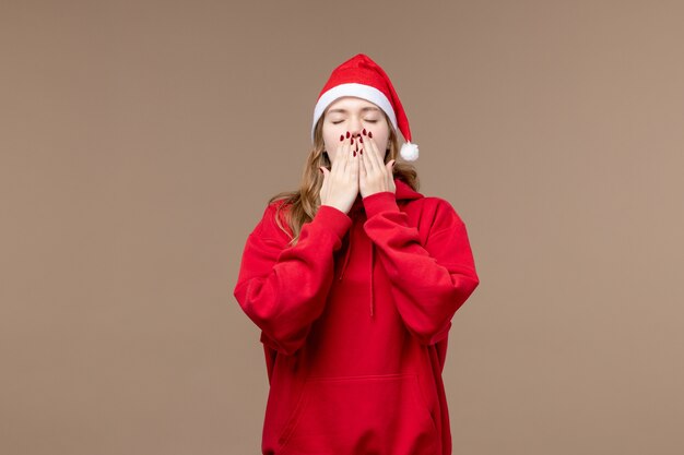 Ragazza di natale di vista frontale che sbadiglia sul natale marrone di feste della donna del fondo